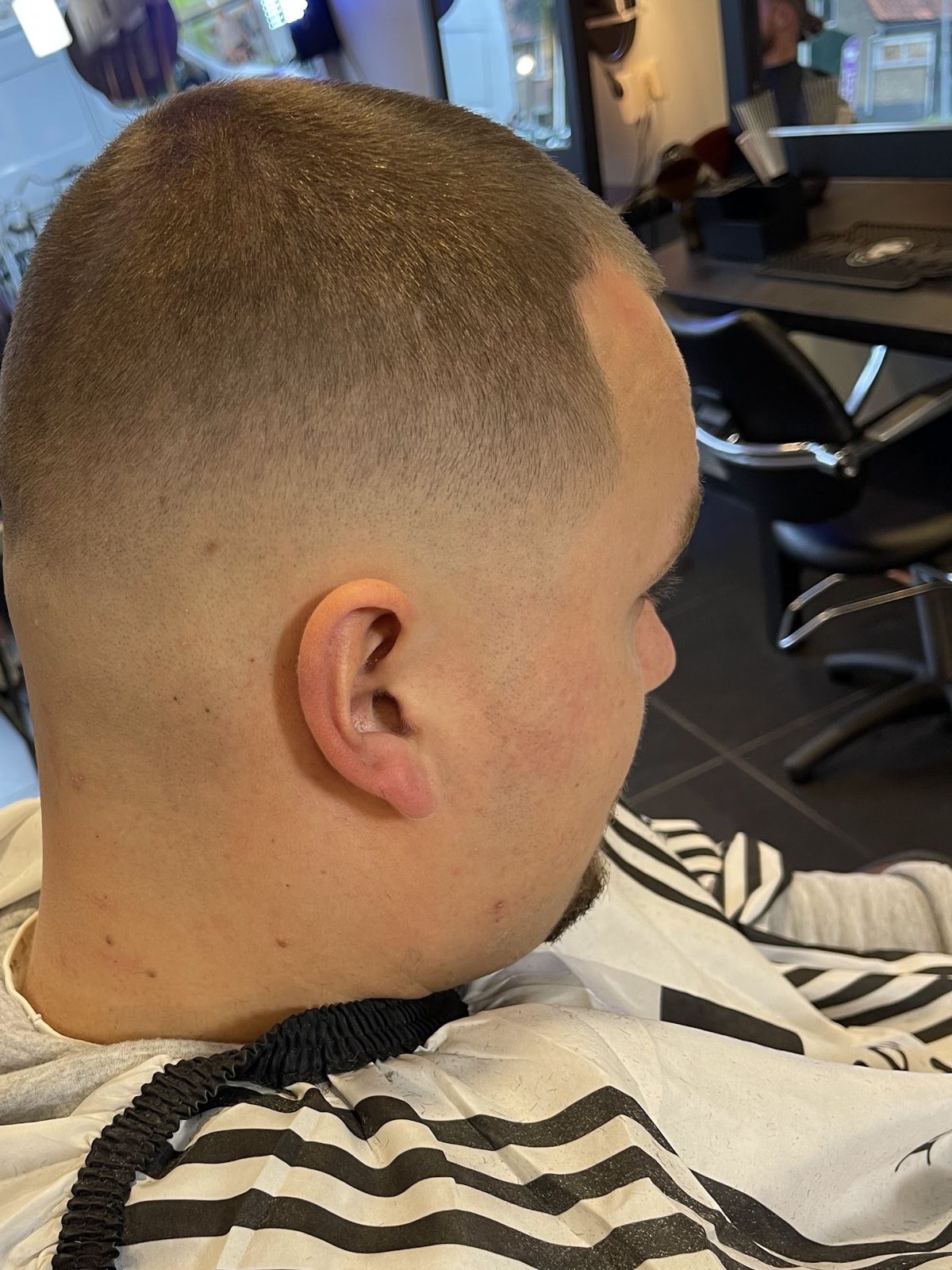 Korte fade van achteren gezien, met de gestreepte kapmantel
